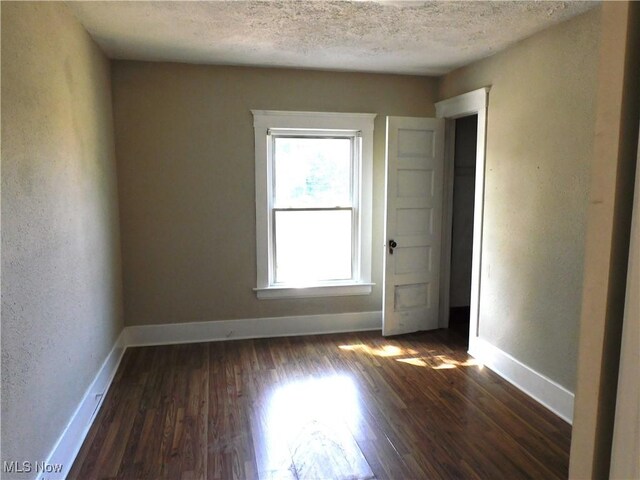 386 Jackson St, Conneaut, OH 44030 - spare room featuring a textured ceiling, baseboards, and dark wood-style flooring