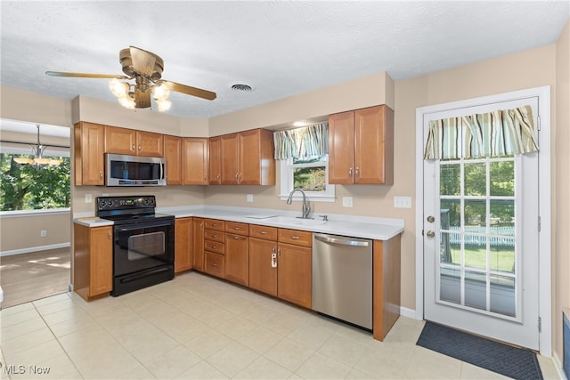 kitchen featuring a textured ceiling, appliances with stainless steel finishes, sink, and a wealth of natural light