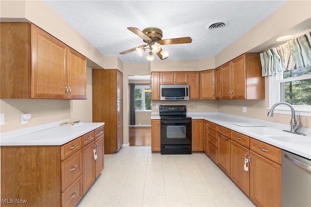 kitchen with stainless steel appliances, ceiling fan, sink, and a textured ceiling