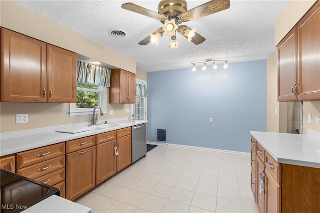 kitchen featuring ceiling fan, sink, dishwasher, light tile patterned floors, and a textured ceiling