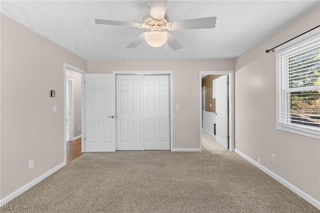 unfurnished bedroom with light carpet, ceiling fan, and a closet