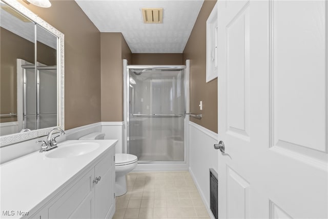 bathroom featuring walk in shower, tile patterned floors, vanity, and toilet