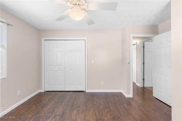 unfurnished bedroom with ceiling fan, a textured ceiling, a closet, and dark wood-type flooring