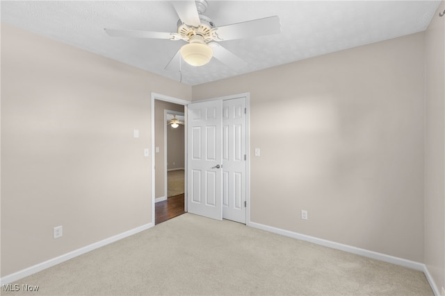 carpeted empty room featuring ceiling fan