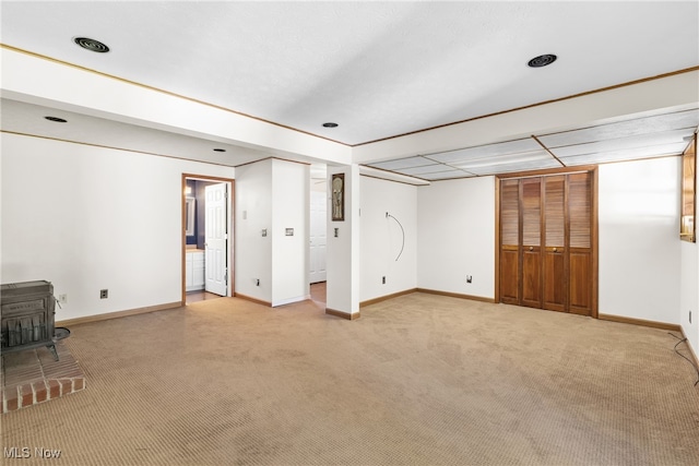 basement with carpet and a wood stove