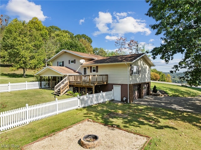 exterior space with an outdoor fire pit, a wooden deck, a front yard, and a garage