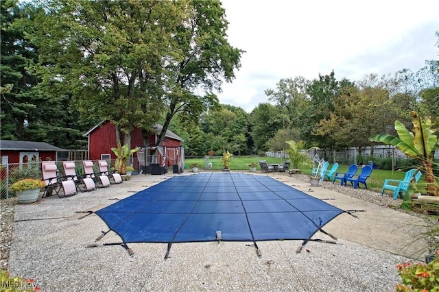 view of swimming pool with an outdoor structure and a patio