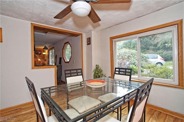 dining space featuring ceiling fan, a textured ceiling, and light hardwood / wood-style floors