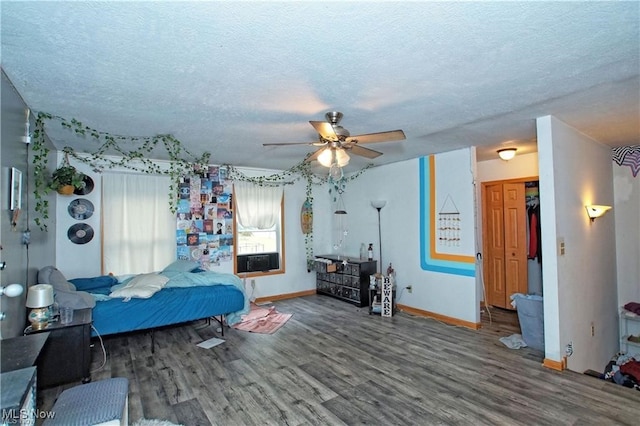 bedroom with wood-type flooring, a textured ceiling, and ceiling fan