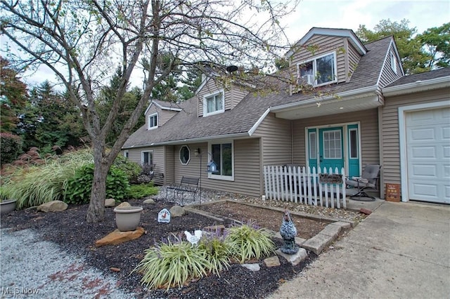 cape cod home with a garage