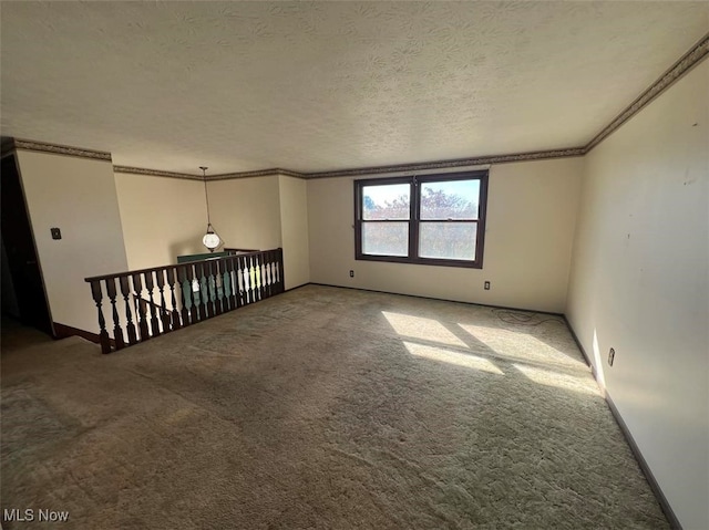 unfurnished room with carpet floors, a textured ceiling, and ornamental molding