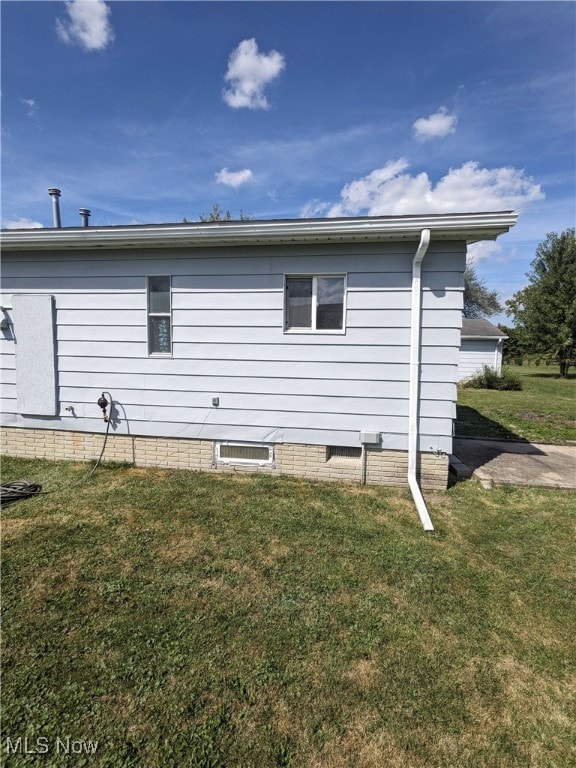 view of side of home with a yard