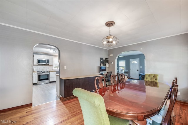 dining area featuring wood-type flooring and crown molding