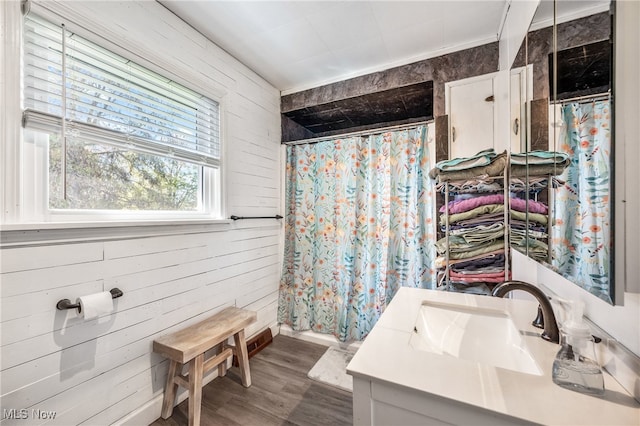 bathroom featuring a shower with curtain, vanity, wood walls, and hardwood / wood-style flooring