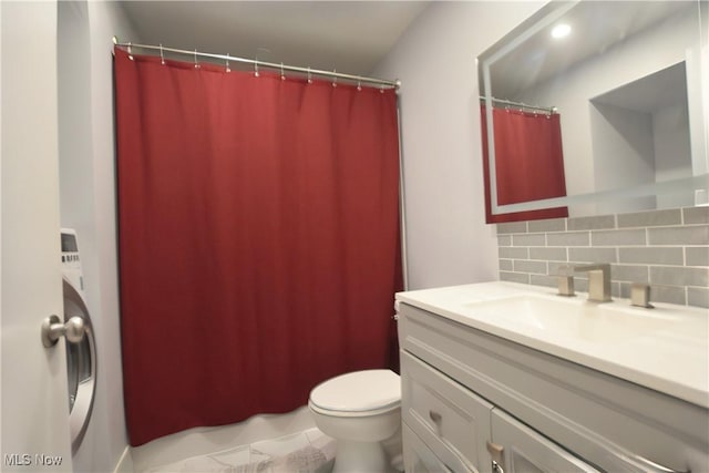 bathroom with vanity, toilet, and decorative backsplash