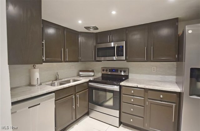 kitchen featuring appliances with stainless steel finishes, sink, dark brown cabinets, and backsplash