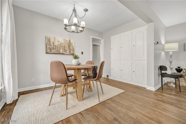 dining space with a chandelier and wood-type flooring