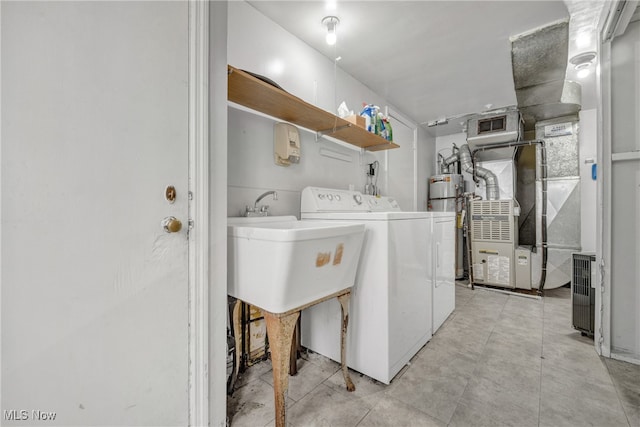 laundry room featuring washing machine and dryer, heating unit, gas water heater, and sink