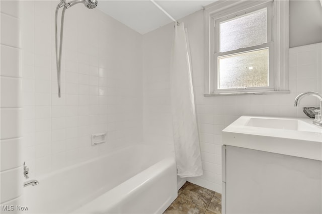 bathroom with vanity, shower / bath combo with shower curtain, and tile walls