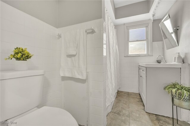 bathroom featuring tile patterned floors, vanity, toilet, and walk in shower