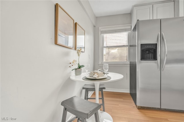 kitchen with stainless steel fridge with ice dispenser and light wood-type flooring