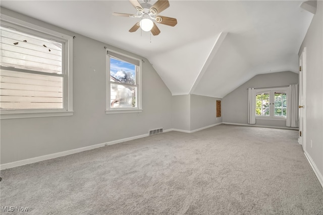 additional living space featuring light carpet, vaulted ceiling, and ceiling fan