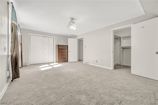 unfurnished bedroom with ceiling fan and light colored carpet