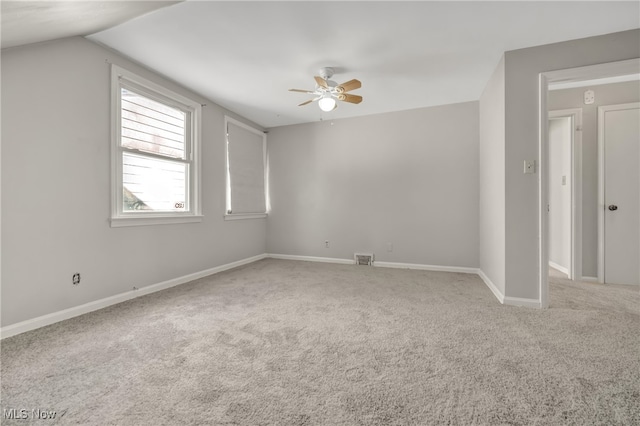 carpeted spare room with ceiling fan and lofted ceiling