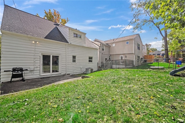 back of house with a yard, a playground, and cooling unit