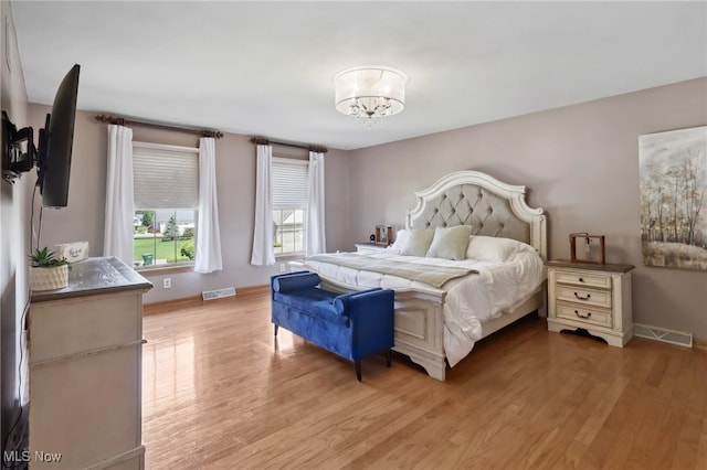 bedroom featuring light hardwood / wood-style floors and a notable chandelier