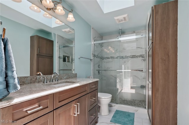 bathroom featuring toilet, tile patterned flooring, vanity, a skylight, and a shower with shower door