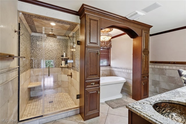 bathroom with tile walls, ornamental molding, separate shower and tub, and vanity