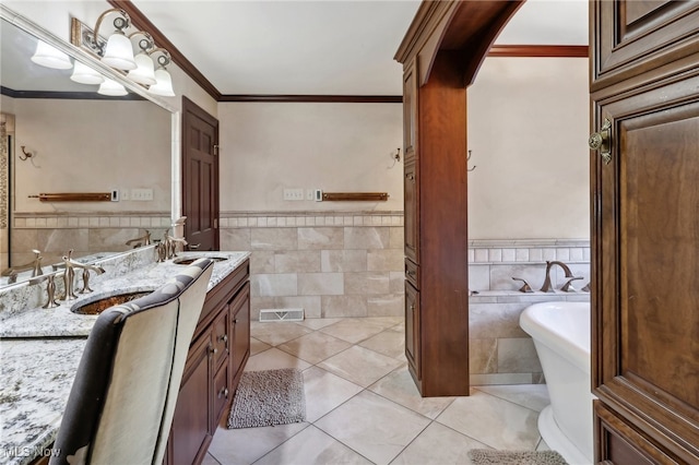 bathroom featuring vanity, crown molding, tile patterned floors, tile walls, and a washtub