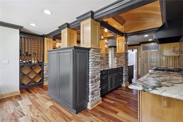 kitchen with ornamental molding, hardwood / wood-style floors, and exhaust hood