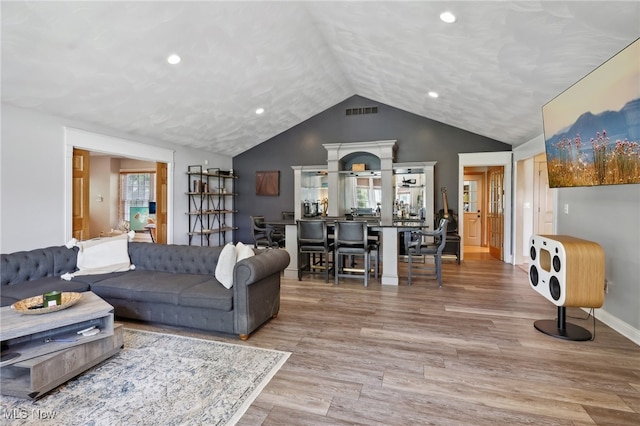 living room featuring wood-type flooring and lofted ceiling