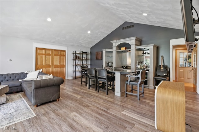 living room with light hardwood / wood-style flooring and vaulted ceiling