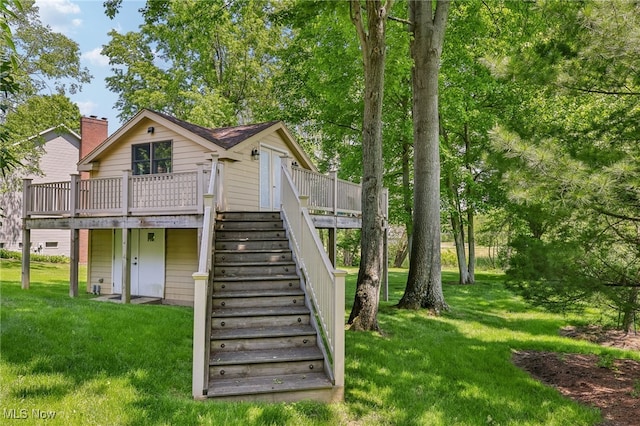 rear view of property with a lawn and a wooden deck