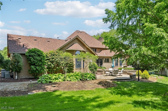 rear view of house with a lawn, central AC, and a patio