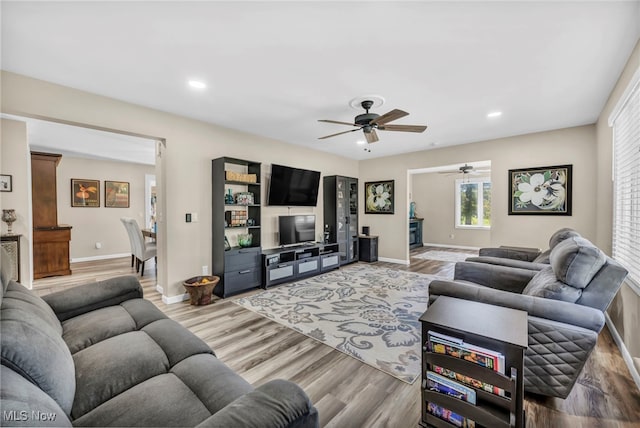 living room with wood-type flooring and ceiling fan