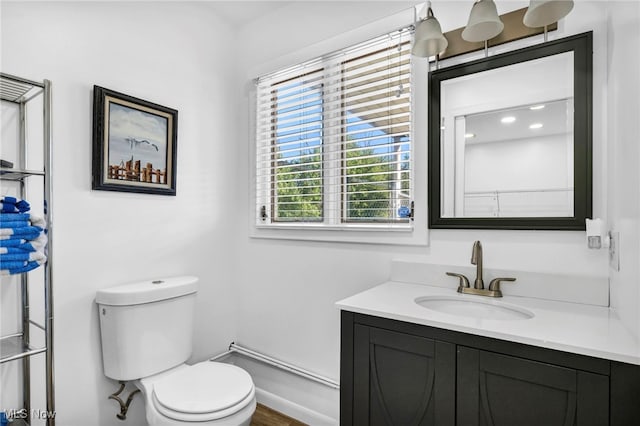 bathroom with hardwood / wood-style flooring, vanity, and toilet