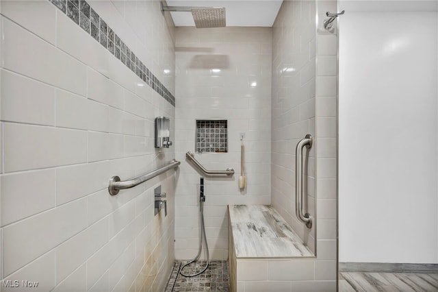 bathroom with hardwood / wood-style flooring and tiled shower