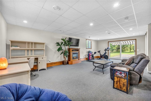 carpeted living room featuring a drop ceiling