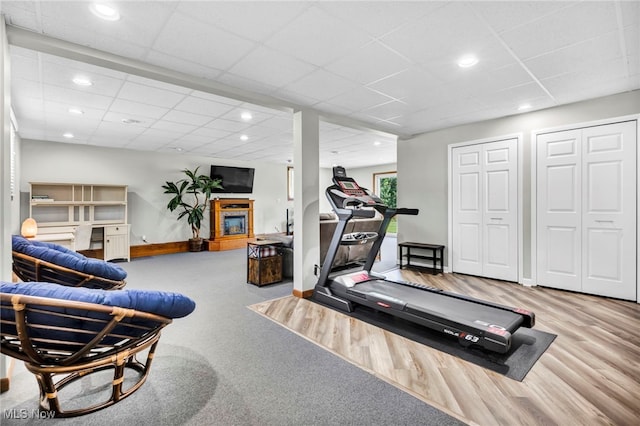 exercise area with wood-type flooring and a paneled ceiling