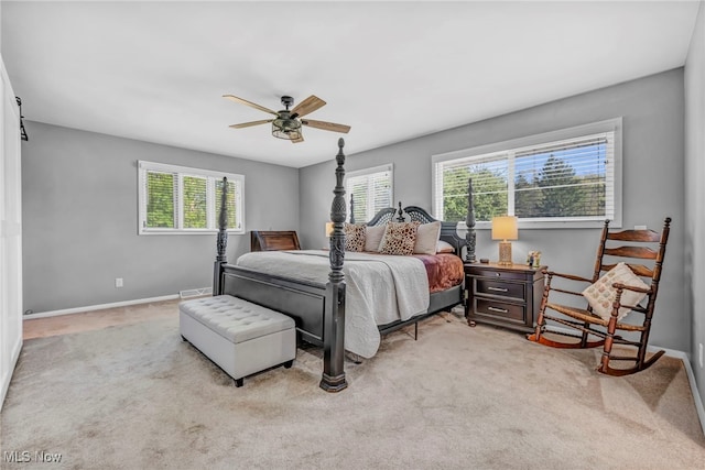 bedroom with light carpet, multiple windows, and ceiling fan