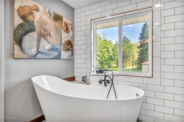 bathroom with tile walls and a bath