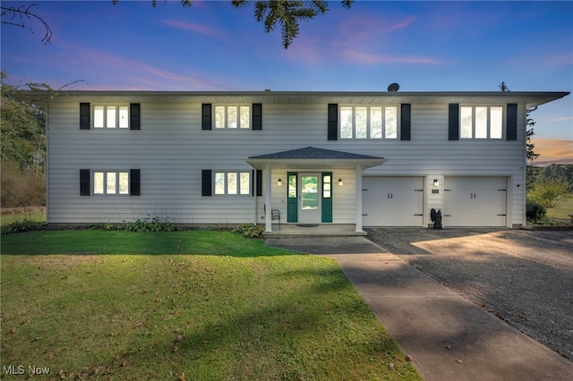 view of front of property with a garage and a yard