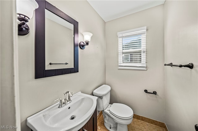 bathroom with toilet, vanity, and tile patterned floors