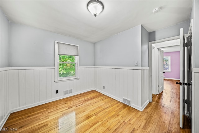 unfurnished room with a healthy amount of sunlight and light wood-type flooring