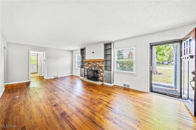 unfurnished living room featuring hardwood / wood-style floors, a fireplace, and a textured ceiling