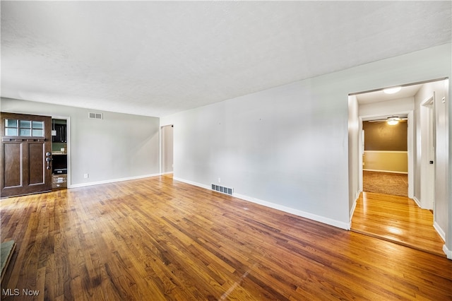 unfurnished living room with hardwood / wood-style floors and a textured ceiling